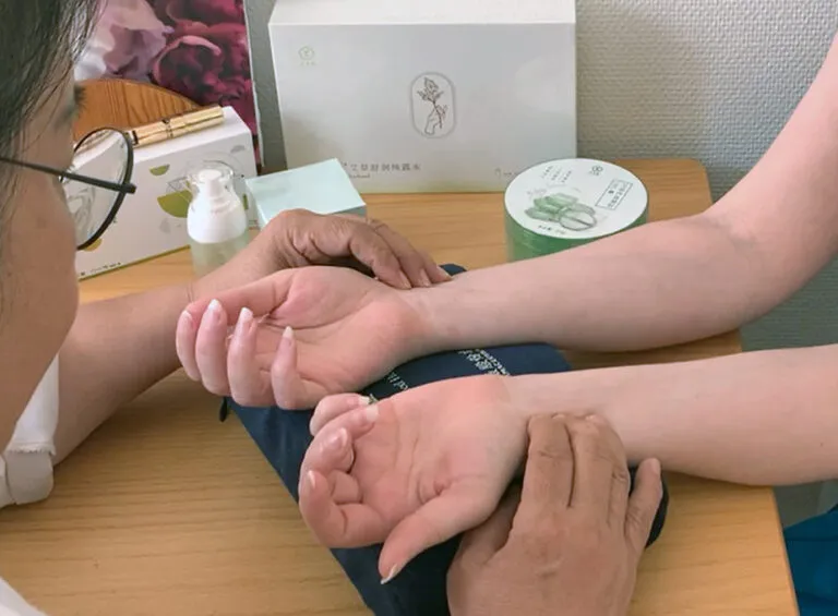 Yanping Wang, kinesisk överläkare, utför pulsdiagnostik på en patient.